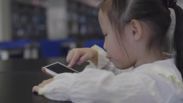Küçük Asyalı Kız Kütüphanede Annesiyle Dijital Tablette Oynuyor — Stok video