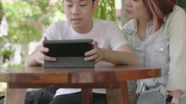 Anne ve Oğul birlikte dijital tablet kullanıyorlar.,