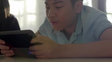 Asyalı kız ve erkek kardeş dijital tablet birlikte kullanma .