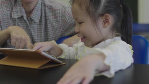 Menina Asiática Brincando Tablet Digital Com Mãe Biblioteca — Vídeo de Stock