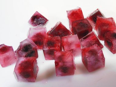                                Kırmızı böğürtlen frosen buz küpleri beyaz bir backgrownd dağılmış.