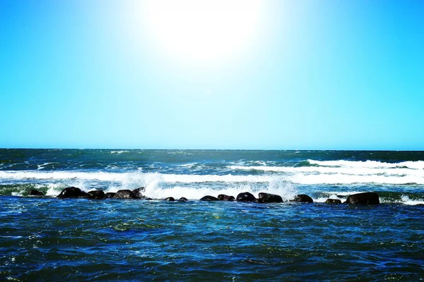 Uma Fileira Grandes Pedras Granito Preto Mar Com Ondas Com — Fotografia de Stock