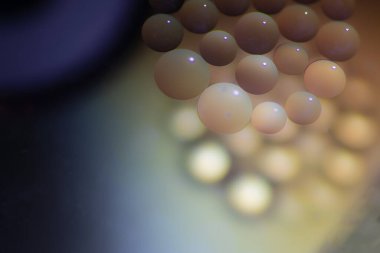 Sudaki yağ damlaları sanatsal ve hayali olarak tasarlanmış bir arka plan yaratır.