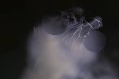 Sudaki yağ damlaları ve süt sanatsal ve hayal gücü açısından soyut bir zemin oluşturur.