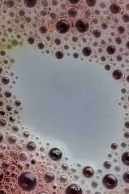 Sudaki hava kabarcıkları, yağ ve süt karışımı sanatsal ve hayal gücü ile tasarlanmış soyut bir zemin oluşturur.