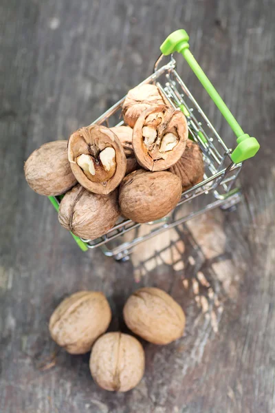 Walnut half in the trolley for food and also a few nuts nearby