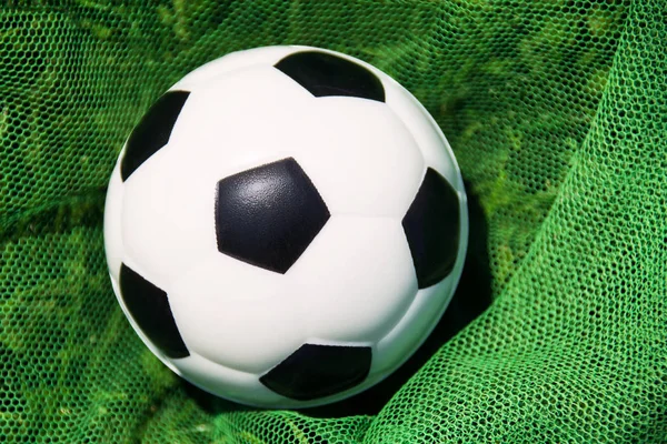 A white soccer ball with a black goal net in the goal net. World Championships, European Champions League