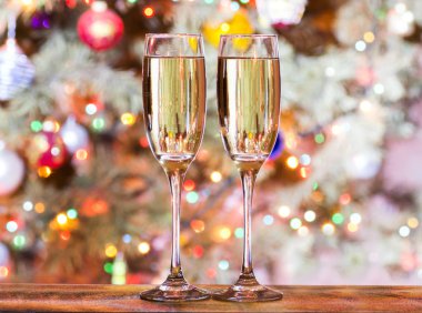 Arka planda şampanya ile Noel bardak renkli ışıklarla süslenmiş oyuncaklar ile Noel ağacı