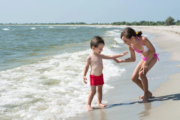 Ablası el küçük kardeşi deniz kıyısı üzerinde verir