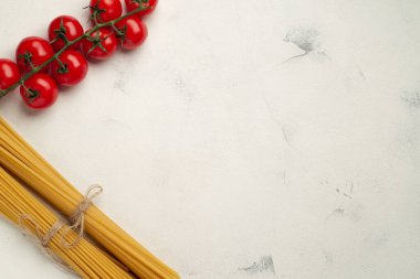Sol tarafta kirazlı domatesler ve yazı manzarası için boş alanı olan iki çeşit spagetti var.