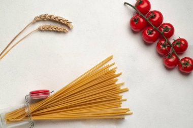 Kavanozda spagetti, kasede makarna ve dikenli domates dalıyla.