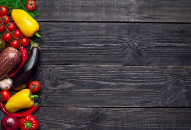 Çok renkli sebzeler solda, ahşap bir arka planda bırakılmış ve mesaj için boş bir yer var..