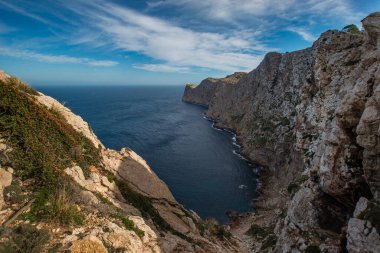 Akdeniz kıyısında dağlar ve yüksek bir yerden mavi gökyüzü olan uçurumlar.
