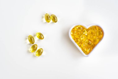 Omega-3 balık yağı kapsülleri vücudun kardiyovasküler sistemi için kalp şeklinde. Yukarıdan görüntüle