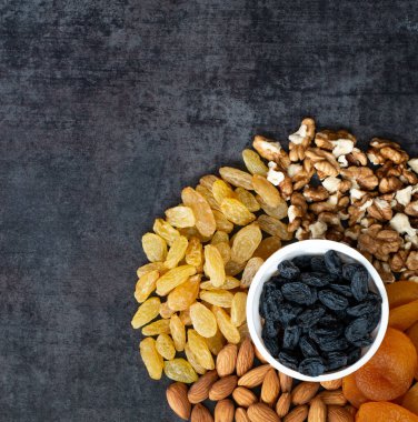 Kardiyovasküler sağlık görüşünü korumak için arka planda beyaz kaselerde kurumuş meyveler.