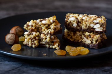 Sağlıklı ve koyu arkaplanda tahıl tatlısı olan siyah bir tabak.