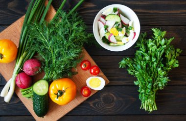 Kesme tahtasında taze sebzeler ve arka planda salata için bitkiler. Diyet Gıda Üst Görünümü