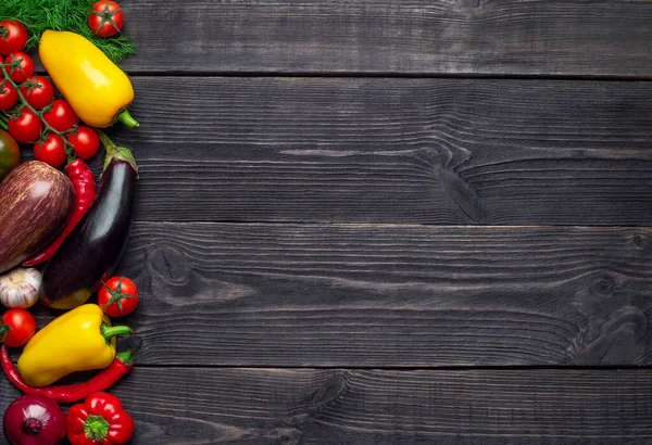 Çok renkli sebzeler solda, ahşap bir arka planda bırakılmış ve mesaj için boş bir yer var..