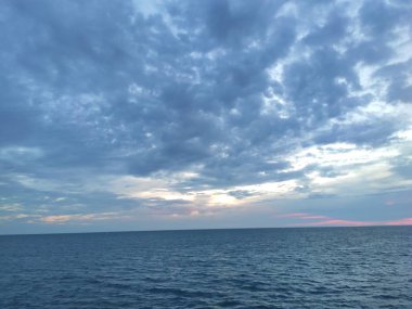 Mavi gökyüzü ve deniz üzerinde bulutlar