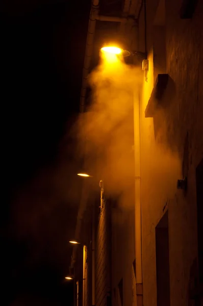 Illuminated street lights in the fog at night. — Stock Photo, Image