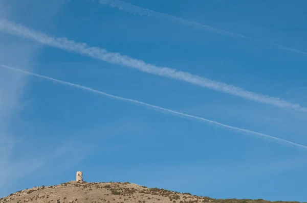 Torre de observación y senderos de aviones en el cielo. — Foto de Stock