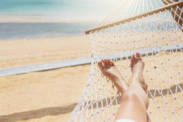 Asian women relaxing in hammock summer holiday on beach