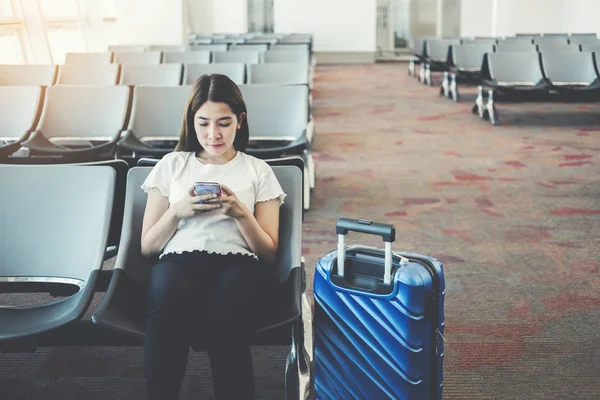 Uluslararası havaalanında Telefon kullanan Turist Kadınlar b bekliyor