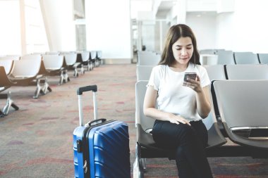 Uluslararası havaalanında Telefon kullanan Turist Kadınlar b bekliyor