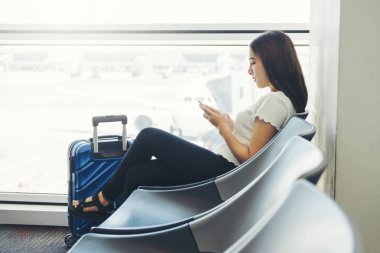 Uluslararası havaalanında Telefon kullanan Turist Kadınlar b bekliyor