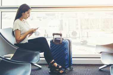 Uluslararası havaalanında Telefon kullanan Turist Kadınlar b bekliyor