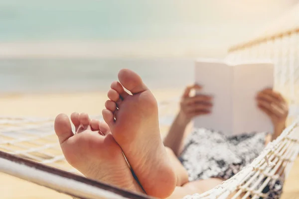 Mujer leyendo un libro sobre la playa de la hamaca en la holida del verano del tiempo libre — Foto de Stock