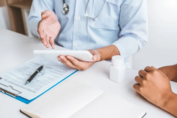 Médico com paciente apresentando sobre as diretrizes de tratamento na escavação — Fotografia de Stock