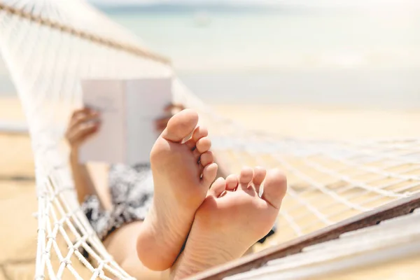 Mujer leyendo un libro sobre la playa de la hamaca en la holida del verano del tiempo libre — Foto de Stock