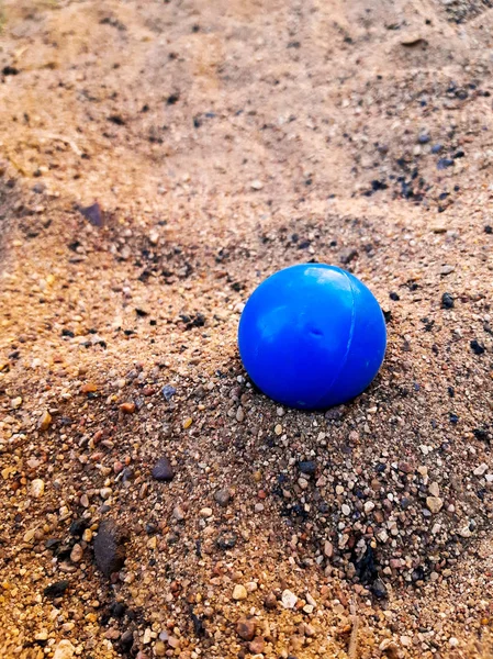 plastic blue ball on sand