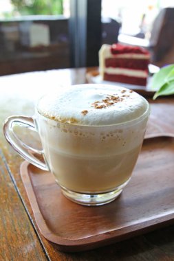 Fincan kahve ve kırmızı kadife kek üzerine ahşap masa