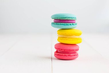 Beyaz ahşap arka plan üzerinde renkli Macaroons.