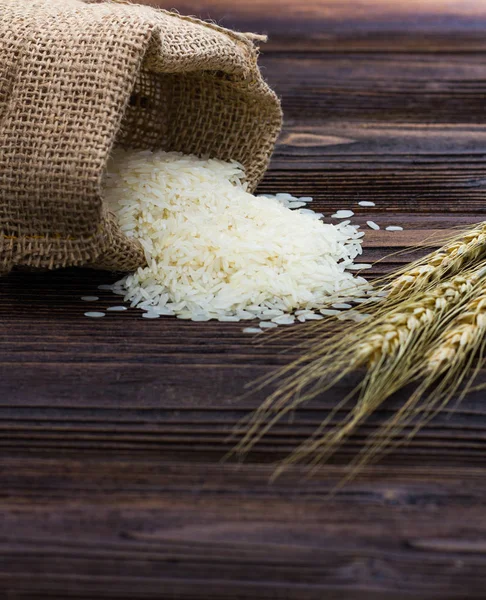 Beyaz Ahşap Masa Üzerinde Paddy Kulak Çuval Pirinç — Stok fotoğraf