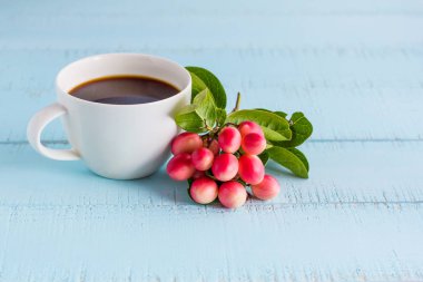 Beyaz kahve fincanı sade kahve ve meyve ahşap tablo.