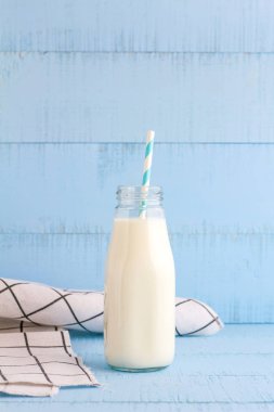 Bir şişe süt mavi ahşap zemin üzerine.