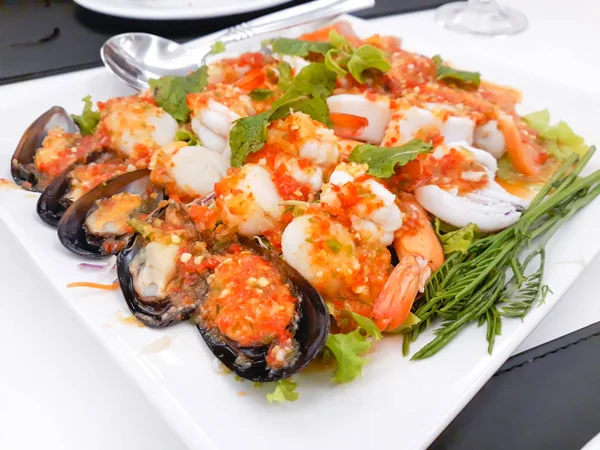 Salade de fruits de mer épicée dans une assiette blanche . — Photo