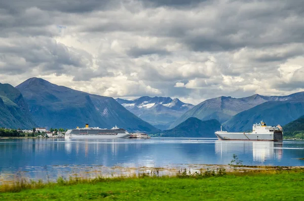 Navio à vela e balsa em um fiorde da Noruega com montanhas atrás e nuvens acima — Fotografia de Stock