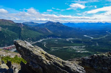 Üzerinde beyaz bulutlar ile mavi gökyüzü ile Mount Healy yürüyüş iz Nenana nehir vadisinin görünümü. Denali Ulusal Parkı