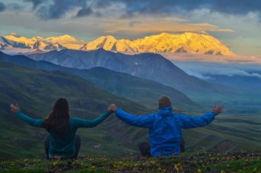 Denali Dağı'nın gün doğumu görünümü - Stony Dome bakan iki kişi ile altın saat boyunca alpenglow ile mt Mckinley zirve. Denali Ulusal Parkı
