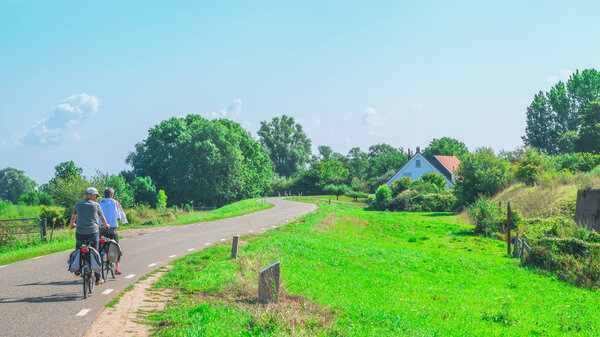 Два неопознанных человека едут по дорожке
