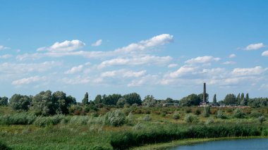 Hollanda 'nın Gelderland, Hollanda' daki Ooijpolder bölgesinde küçük bir köyün önündeki göl.