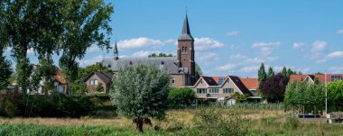 Hollanda 'nın Gelderland kentindeki Waal nehrinin taşmasını önlemek için bir hendek tarafından korunan geleneksel Hollanda köyü Ooij