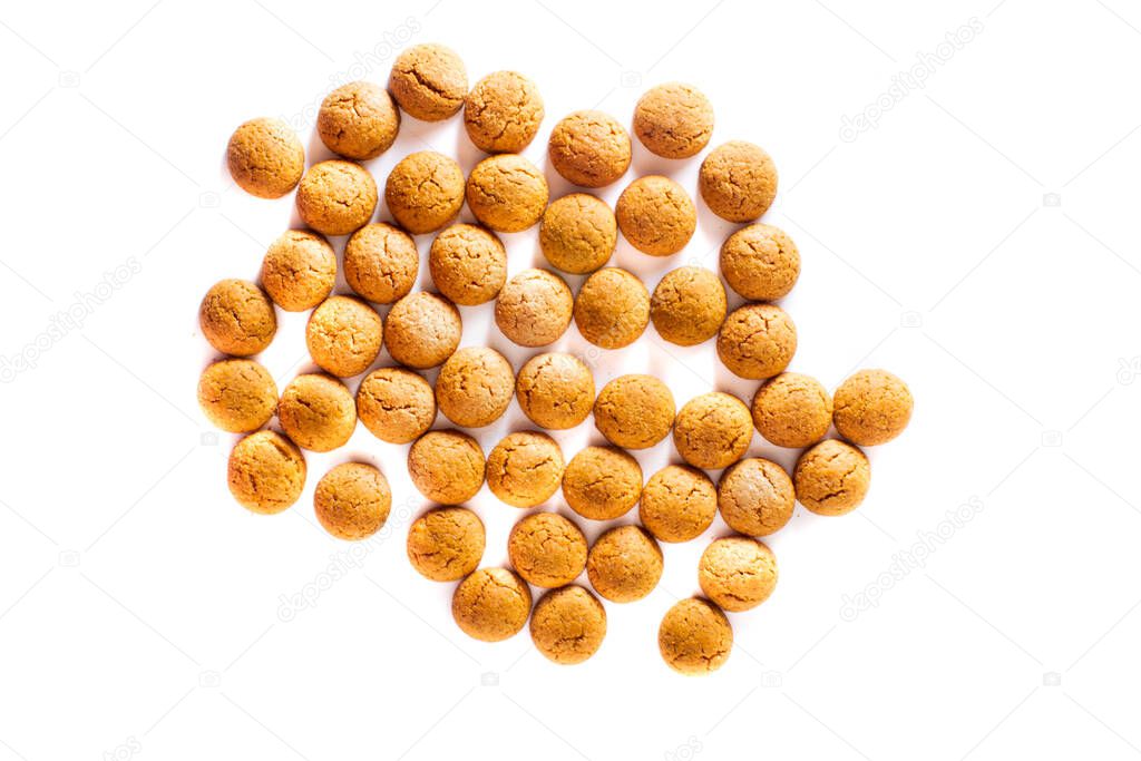 Bunch of scattered Pepernoten cookies from above as Sinterklaas decoration on white background for dutch sinterklaasfeest holiday event on december 5th