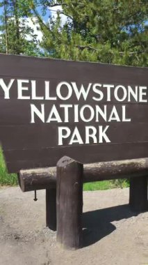 Yellowstone 07.15.2025. Iconic Yellowstone Ulusal Parkı giriş tabelası, yeşillik ile çerçevelenmiş, doğa severler ve keşfetmek isteyen maceraperest gezginlerin ilgisini çeken pitoresk bir sahne oluşturuyor.