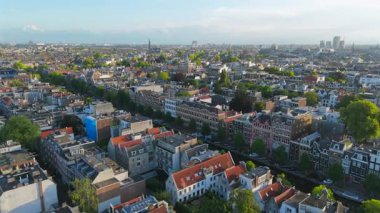 Amsterdam 'ın çarpıcı hava manzarası canlı şehir manzarası, tarihi mimariyi bereketli yeşillikle harmanlamak, hareketli şehir çevresine ferahlatıcı bir dokunuş katıyor.