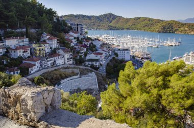 Türkiye, Fethiye, çok sayıda yat ile liman manzarası ve güneş ışınları arka planda güzel dağlar